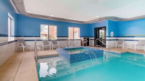 An indoor swimming pool with blue-tiled walls, white chairs, and a small hot tub area. - Best Western Plus Olathe Hotel (Olathe)