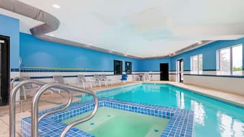 Una piscina techada, sillones reclinables de piscina