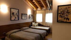 A room with two beds, wooden ceiling beams, and framed artwork on the walls. - Locanda Al Sole (Castello di Godego)