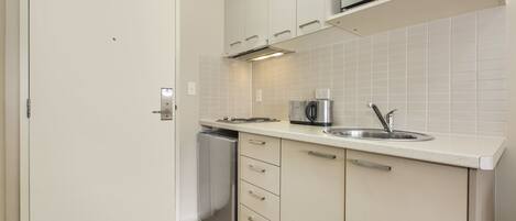 A modern kitchen with white cabinets, a stainless steel sink, and a built-in microwave.