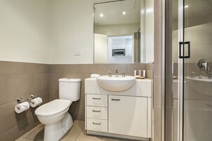 A modern bathroom with a toilet, sink, and shower.