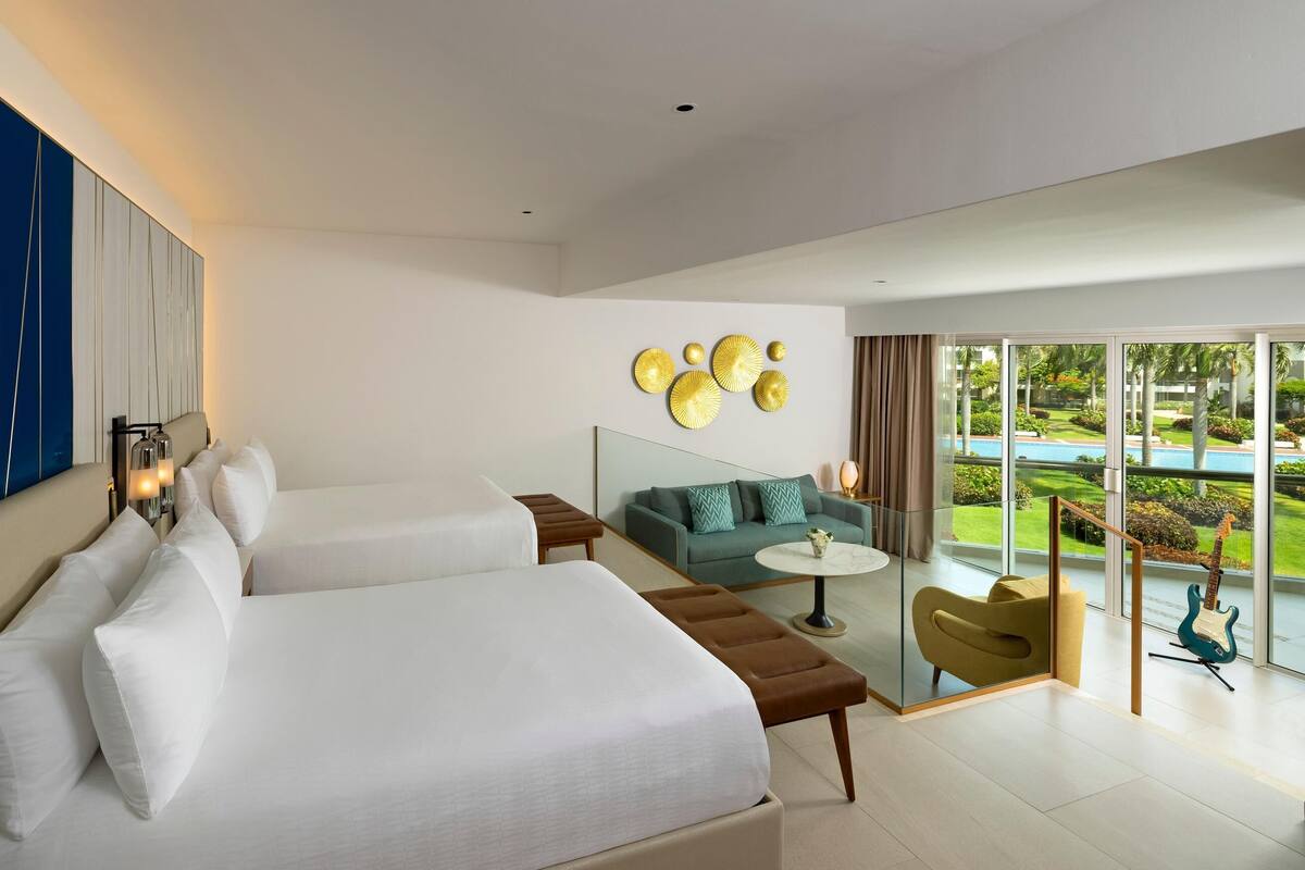 Ein modernes Hotelzimmer mit zwei Betten, einer Couch, einem Glastisch und Blick auf einen Pool und Grünflächen.