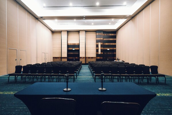 A conference room with rows of chairs and tables, a blue carpet, and a high ceiling with recessed lighting. - Hard Rock Hotel & Casino Punta Cana an All-Inclusive Resort (Punta Cana)