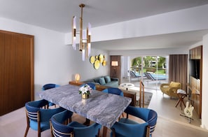 A modern dining area with a marble table, blue chairs, and a chandelier.