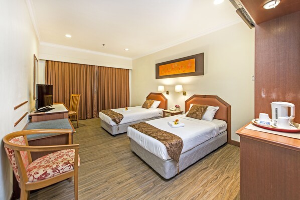 A hotel room with two beds, a desk, a chair, a TV, and a coffee maker. - Hotel 81 Tristar (Singapore)