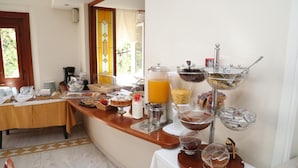 Montaje de desayuno buffet con diferentes opciones de comida y un dispensador de jugo.