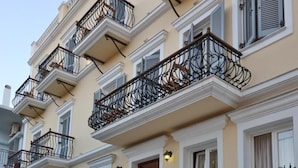 Un edificio de varios pisos con balcones, un letrero que dice "Alyan" y una escalera que conduce a la entrada.