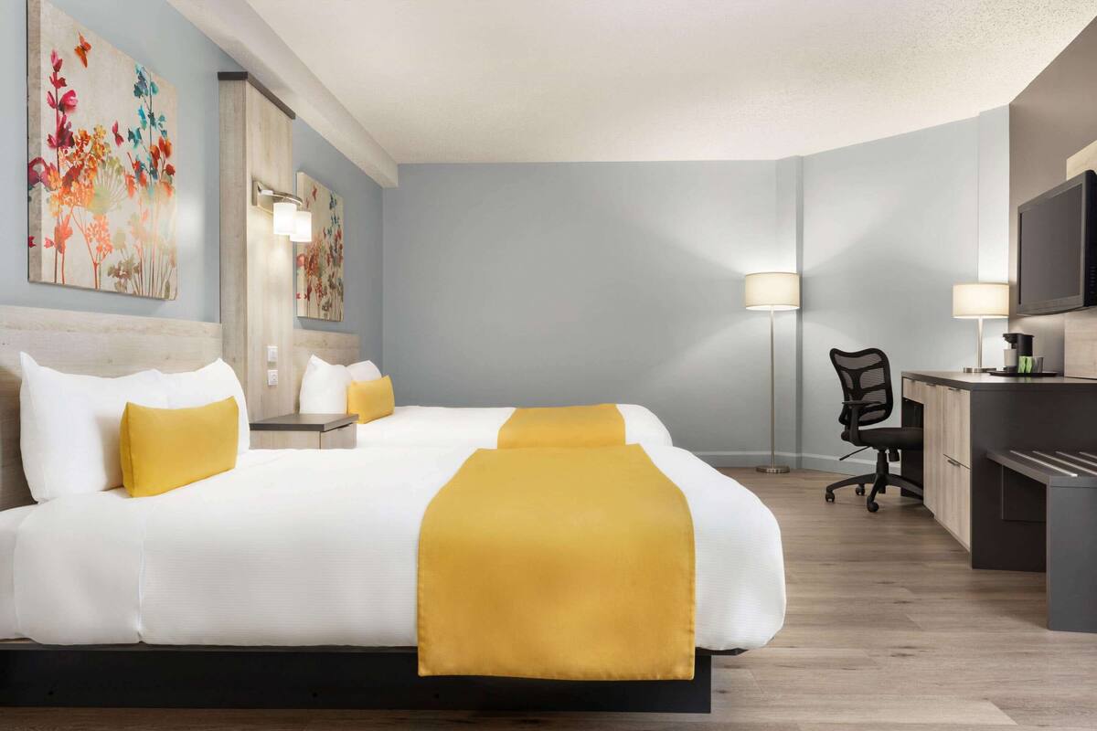 Ein Hotelzimmer mit einem großen Bett, einem Schreibtisch und einem Sessel.
