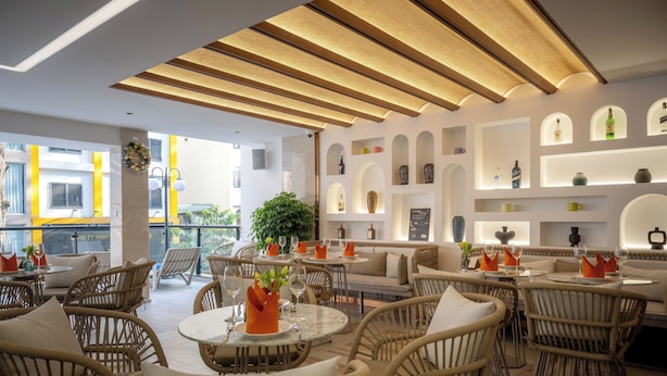 A modern outdoor dining area with wicker furniture and a variety of table settings.