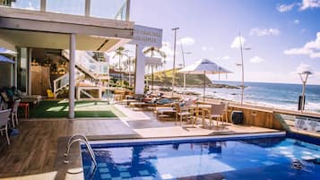 Una piscina al aire libre, camas de piscina gratis, sombrillas
