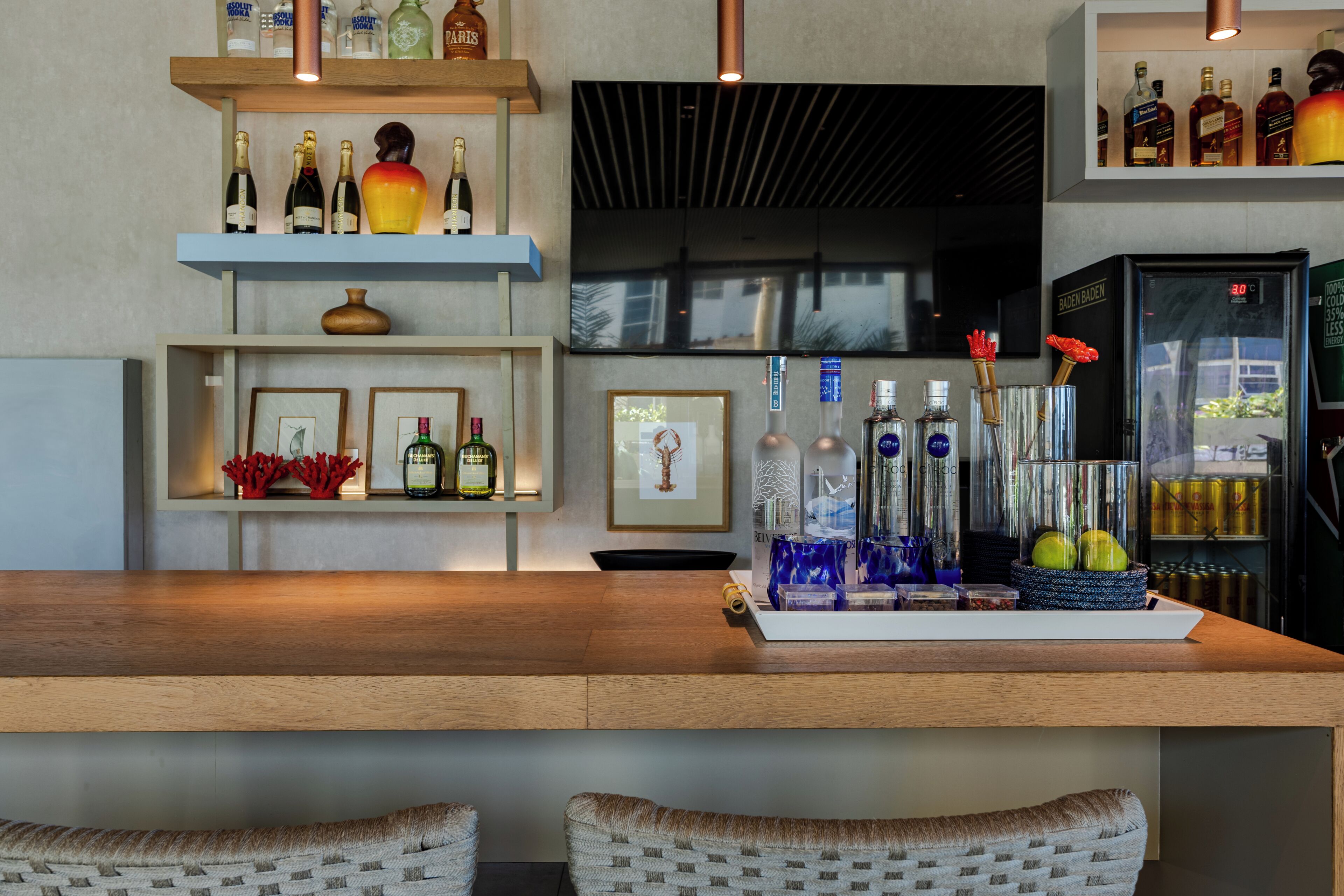 Een bar met flessenkasten, een houten toonbank en ingelijste foto's.