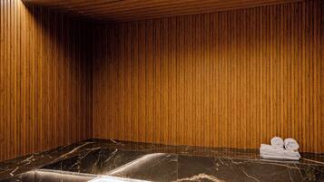 Una habitación con paneles de madera, encimera de mármol y toallas.