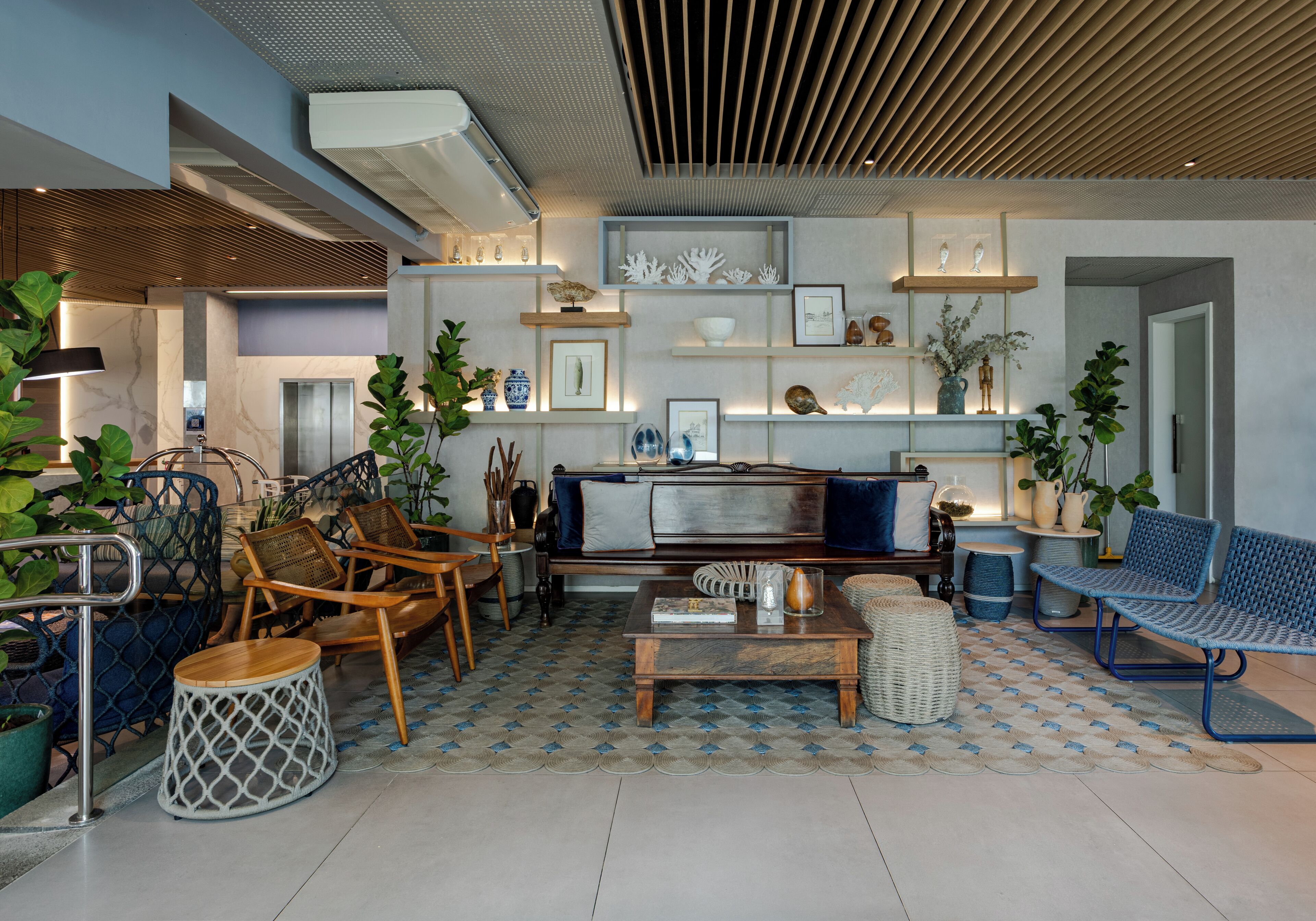 A modern living room with a sofa, chairs, a coffee table, and shelves with decorative items.