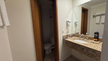 Baño con lavamanos, espejo y toallero.