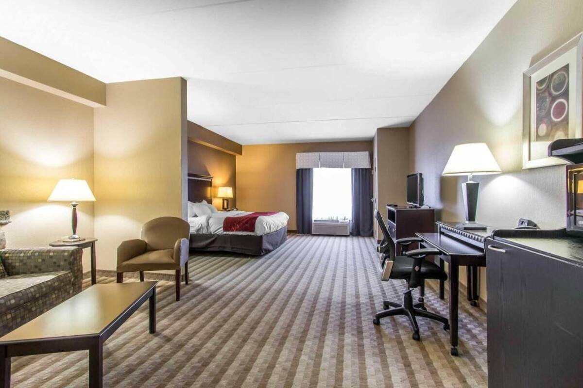 Ein Hotelzimmer mit Bett, Schreibtisch, Stuhl und Fernseher.