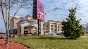 Un hotel con un letrero que dice "Comfort Suites" y una fachada de edificio moderna.