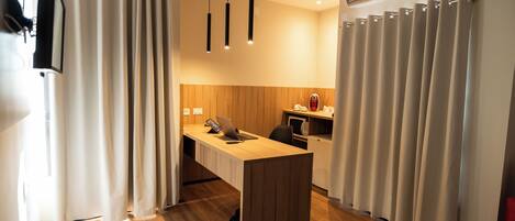 A modern kitchen with a wooden countertop, a built-in oven, and a coffee machine.