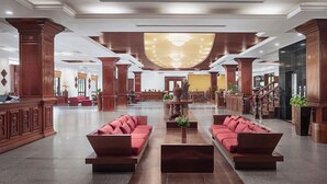 A spacious lobby with a central seating area, wooden columns, and a chandelier. - Angkor Paradise Hotel (Siem Reap)