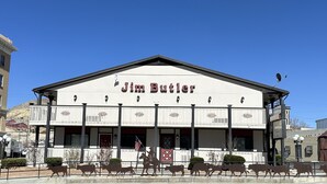 A building with a sign reading "Jim Butler" and a cowboy statue in front. - Jim Butler Inn & Suites (Tonopah)