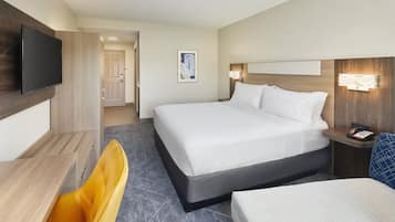 A hotel room with a bed, a television, a desk, and a chair.