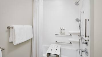 A modern bathroom with a bathtub, shower, and towel rack.