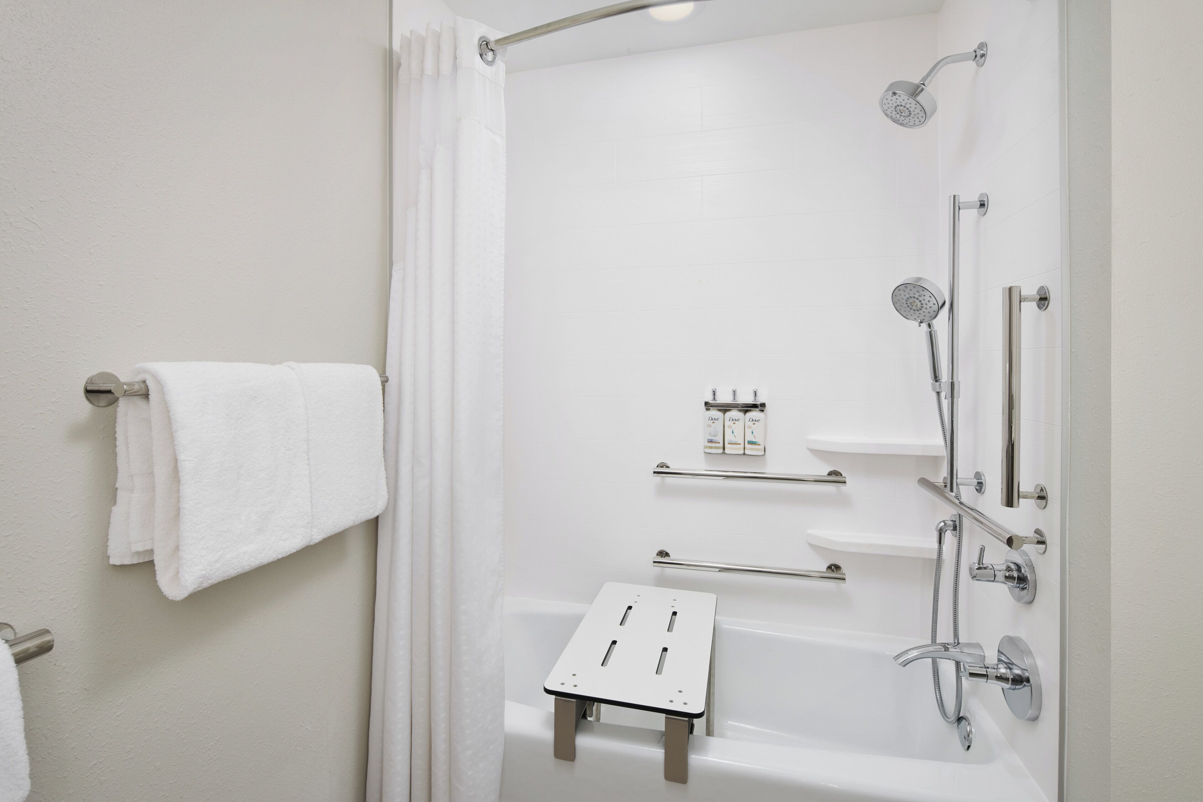 A modern bathroom with a bathtub, shower, and a towel rack.