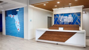 Un mostrador de recepción de diseño moderno, una pared azul con un mapa y un detalle de madera.