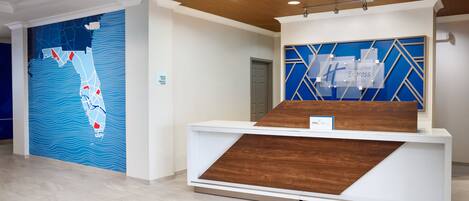 Un mostrador de recepción de diseño moderno, una pared azul con un mapa y un detalle de madera.