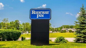 A sign for Rodeway Inn with a clear blue sky in the background. - Rodeway Inn Lakeville - Finger Lakes Area (Lakeville)