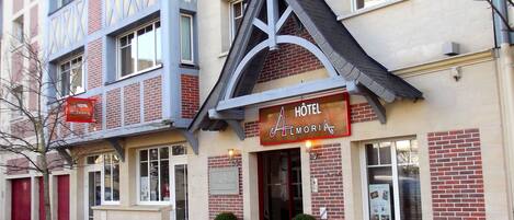 A hotel with a distinctive architectural style, featuring a prominent triangular roof and a sign that reads "HOTEL Almoria."