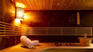 Una sauna con bancos de madera, una toalla y un recipiente etiquetado como 'alpha' sobre una mesa de madera.