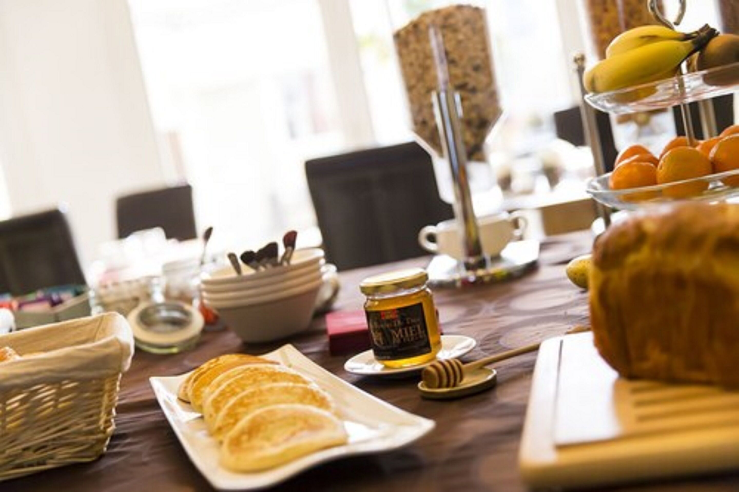Un bufé de desayuno con pasteles, frutas y miel.