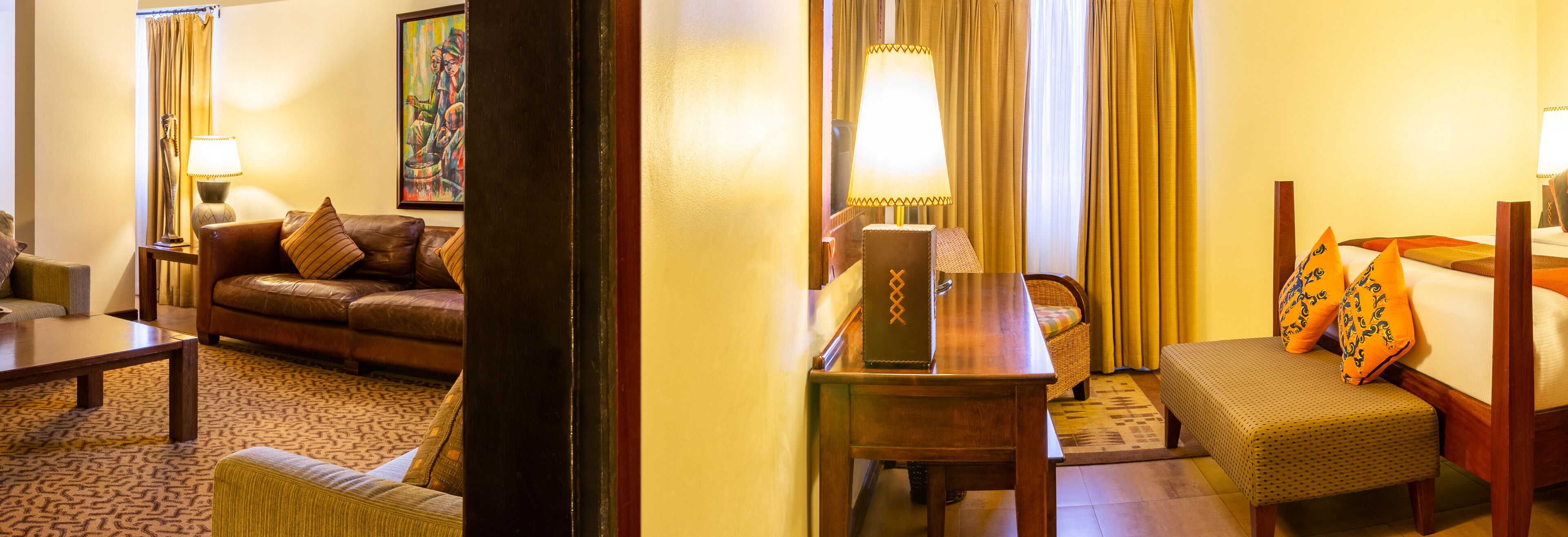 Una habitación de hotel acogedora con un sofá de cuero, una mesa de centro de madera, un sillón pequeño y una mesita de noche con lámpara.