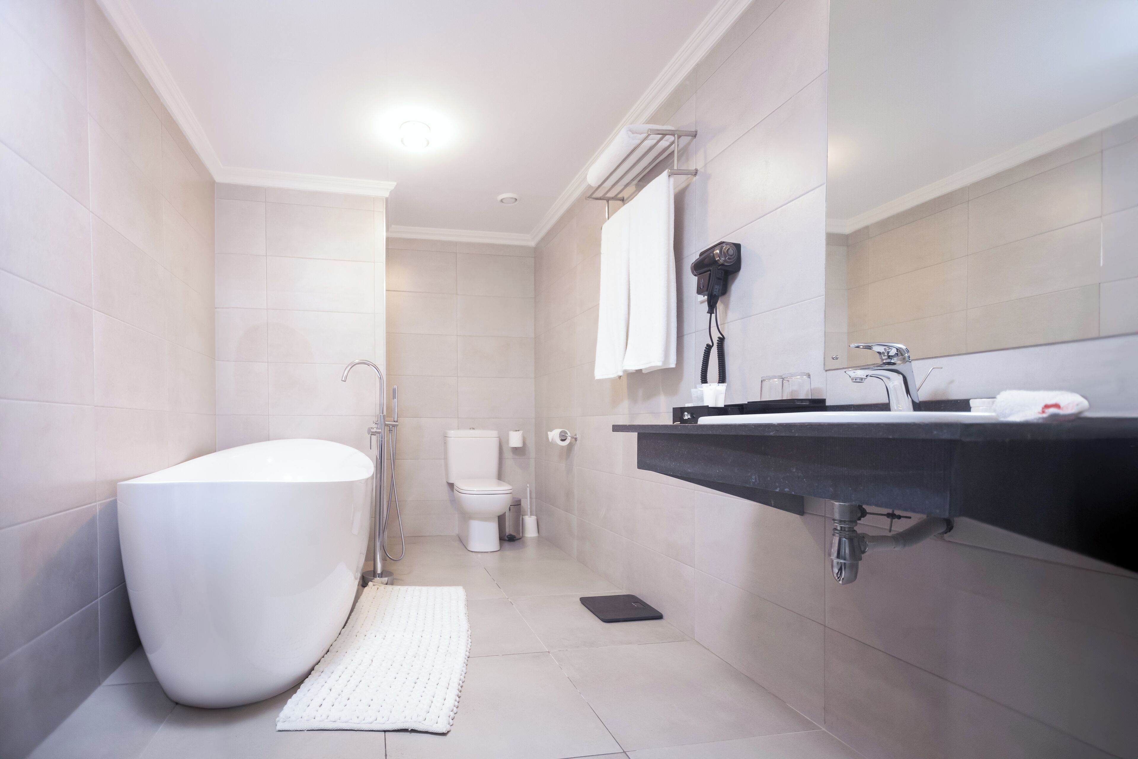 suite (afropolitan) | bathroom | separate bathtub and shower, designer toiletries, hair dryer, slippers