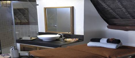 A bathroom with a large sink, mirror, and towel rack.