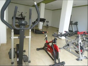 A gym with various exercise equipment including treadmills, stationary bikes, and elliptical machines.