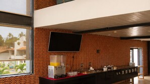 Un interior moderno con zona de comedor, encimera de cocina y lámpara colgante.