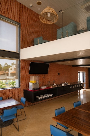 Un interior moderno con zona de comedor, encimera de cocina y lámpara colgante.