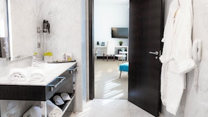 A modern bathroom with a marble vanity, a towel rack, and a shower area. - Hotel Nuevo Boston (Madrid)