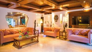A spacious living room with two plush sofas, a coffee table, and a large mirror. - Hotel Emperor Palms at Karol Bagh (New Delhi)