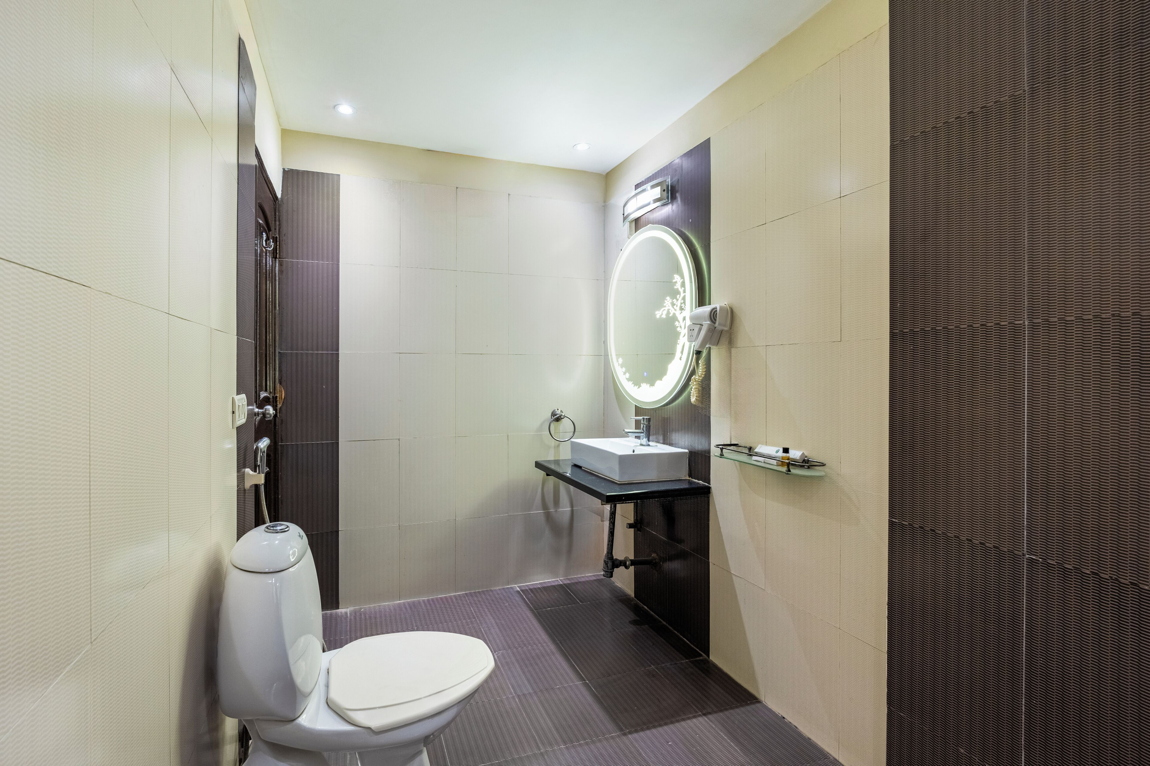 A modern bathroom with a toilet, sink, and mirror.