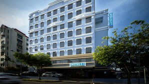 Un hotel moderno con un letrero llamativo, varios pisos y un área de estacionamiento.