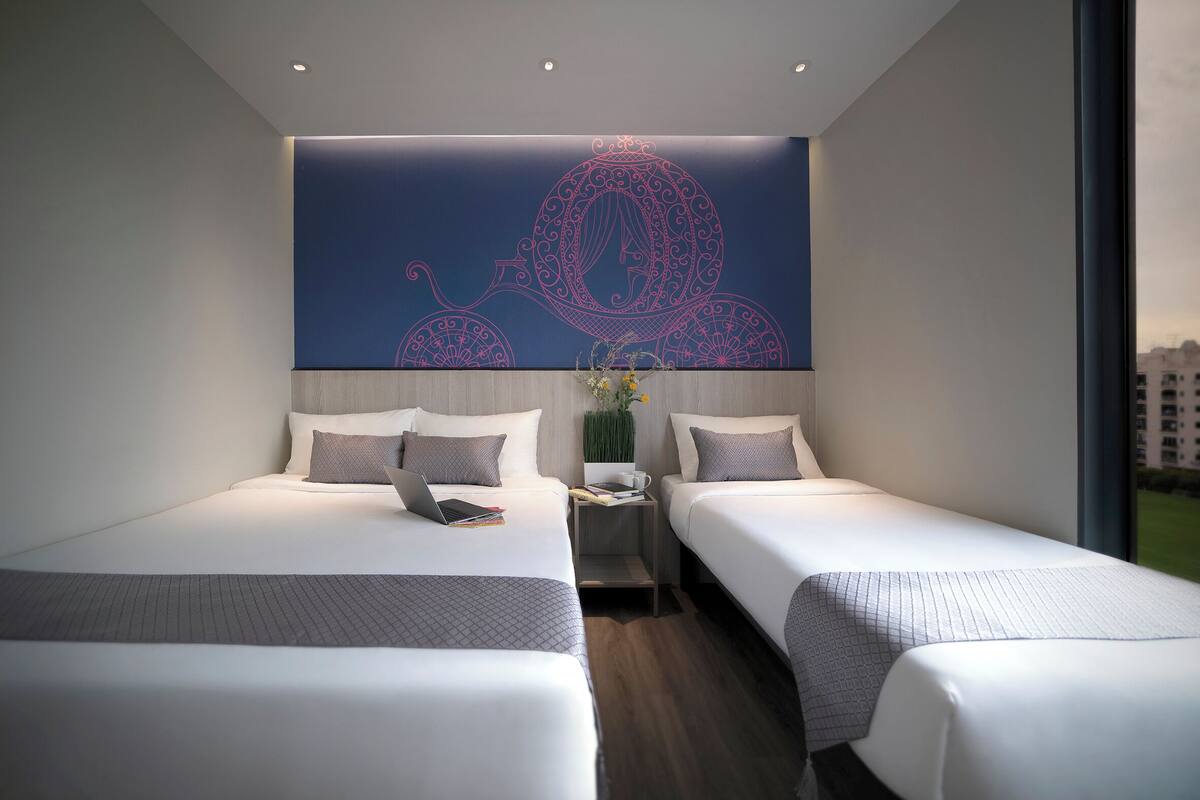 A modern hotel room with two beds, a nightstand, and a decorative wall piece.