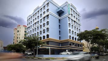 Un hotel de varios pisos con un diseño moderno, que cuenta con balcones y una entrada destacada.