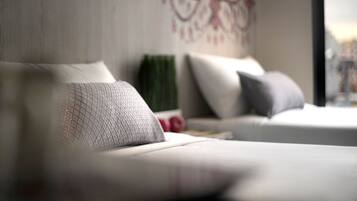 Un dormitorio moderno con sofá cama, almohadas decorativas y una obra de arte en la pared.