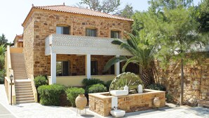 A stone building with a tiled roof, a staircase, and a water wheel. - Grecian Castle Hotel (Chios)