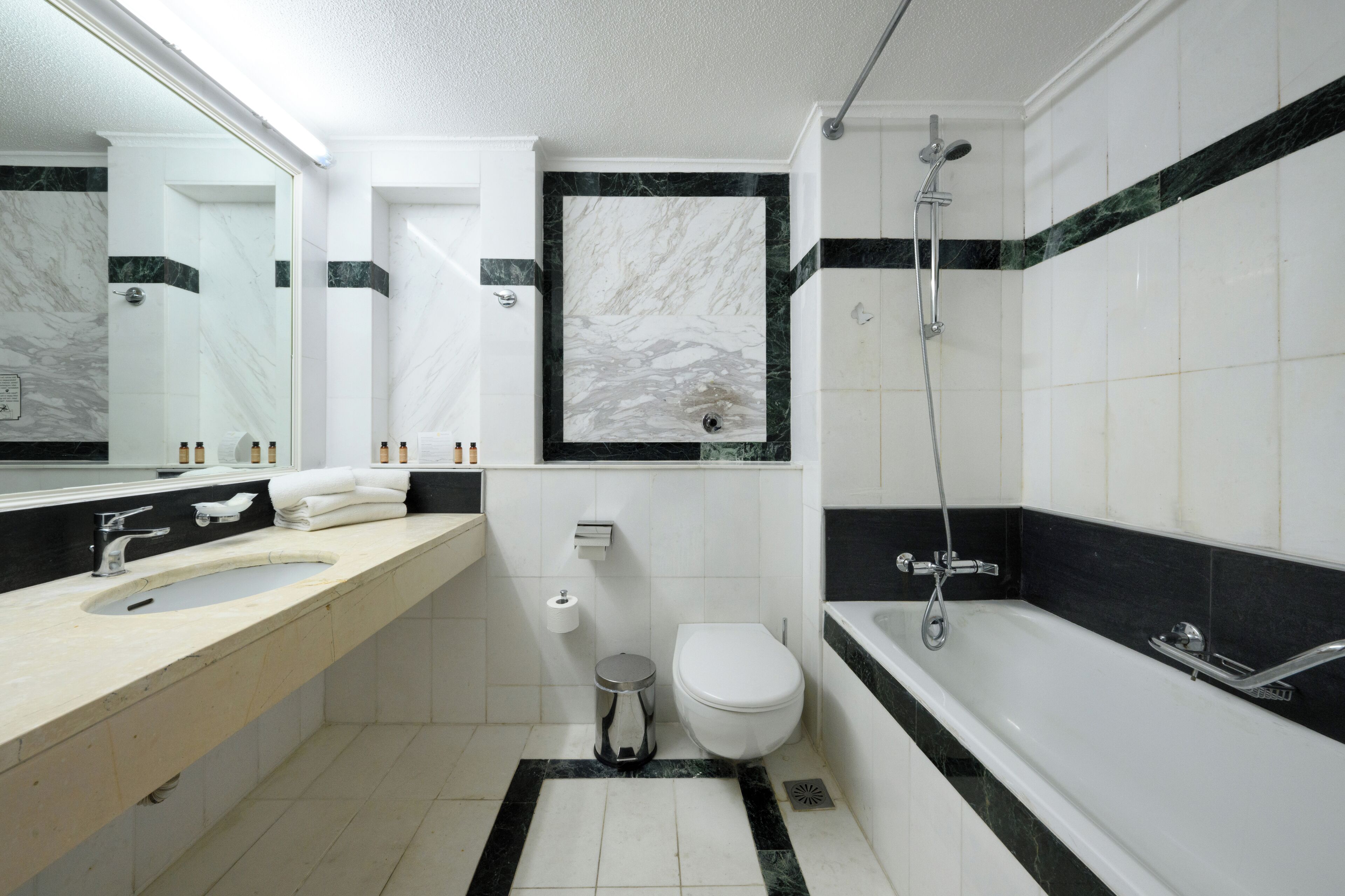 Un bagno moderno con lavabo, water e vasca in marmo.
