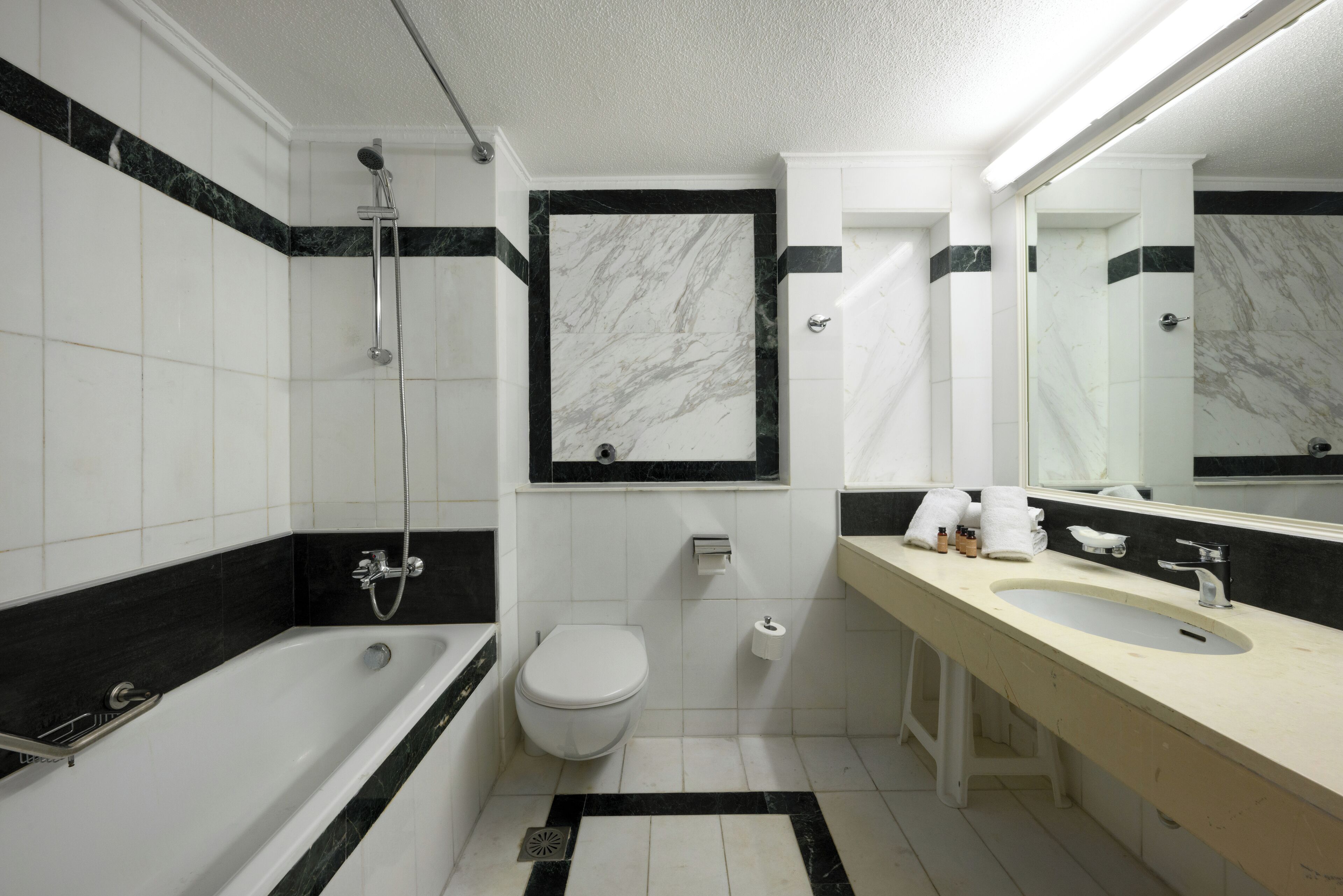 A modern bathroom with a bathtub, toilet, and sink.
