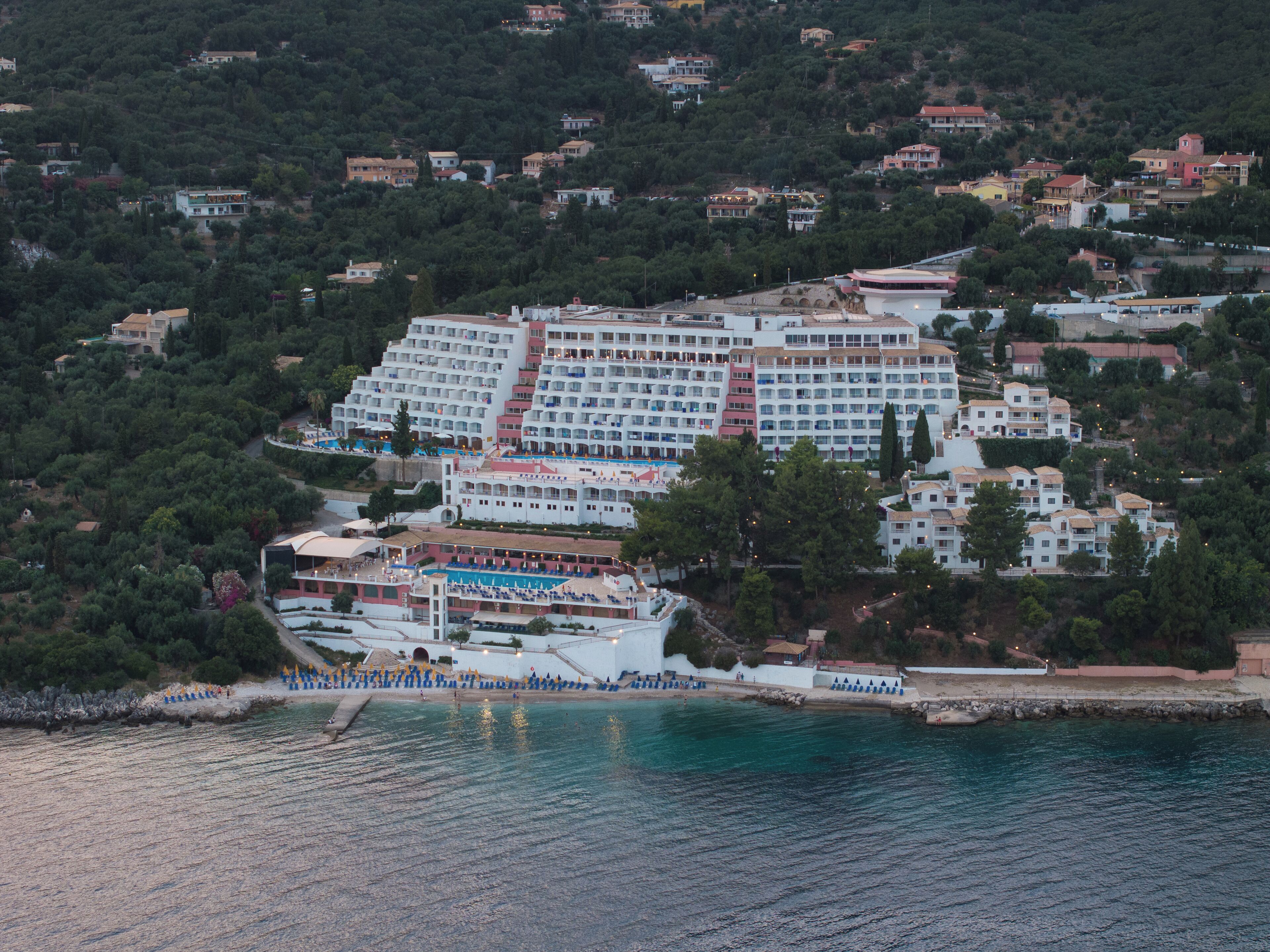 A large hotel with multiple floors, a pool area, and a beachside location.