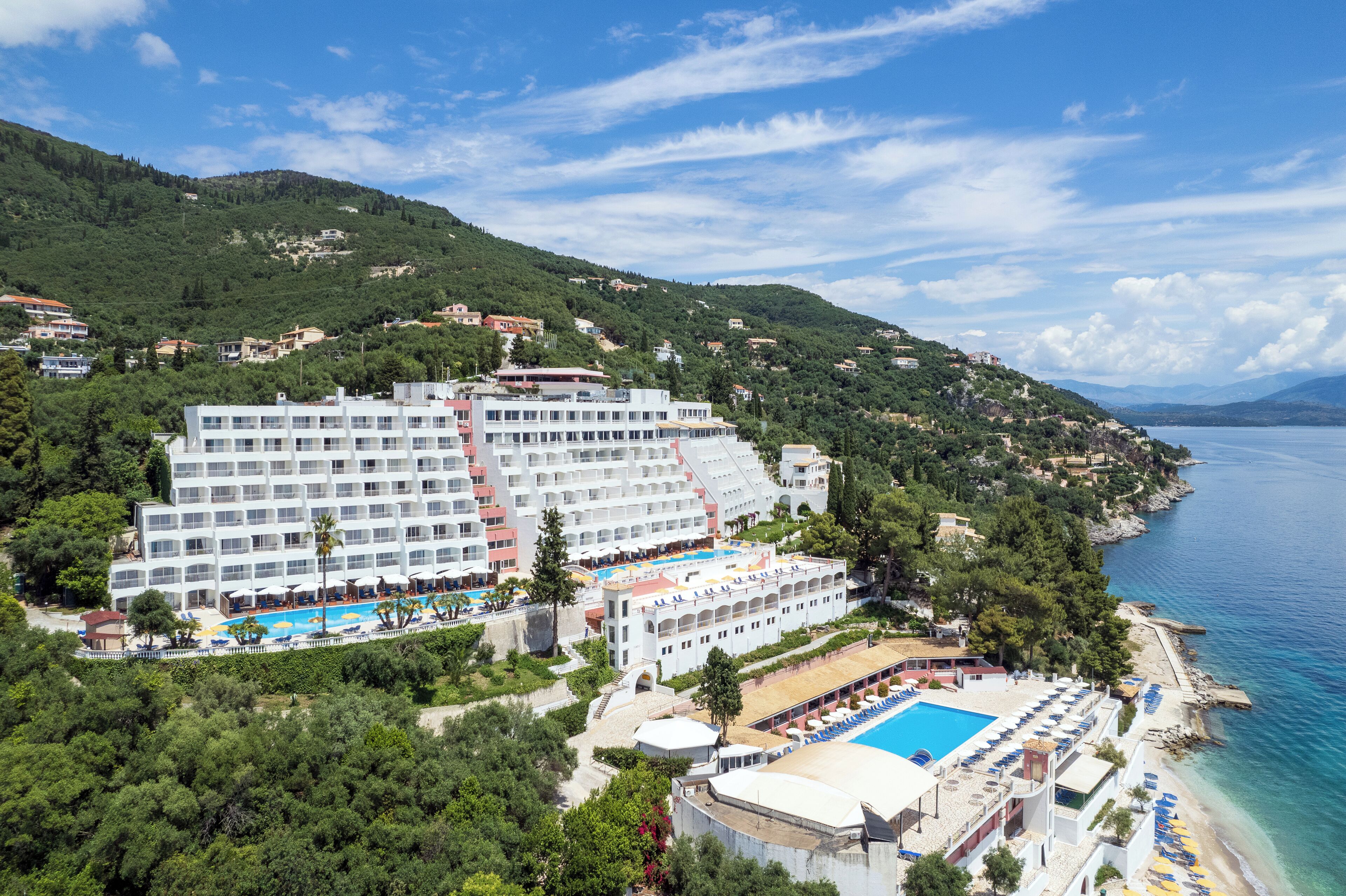 Ein großes Hotel mit mehreren Gebäuden, einem Schwimmbad und einer Strandanlage.